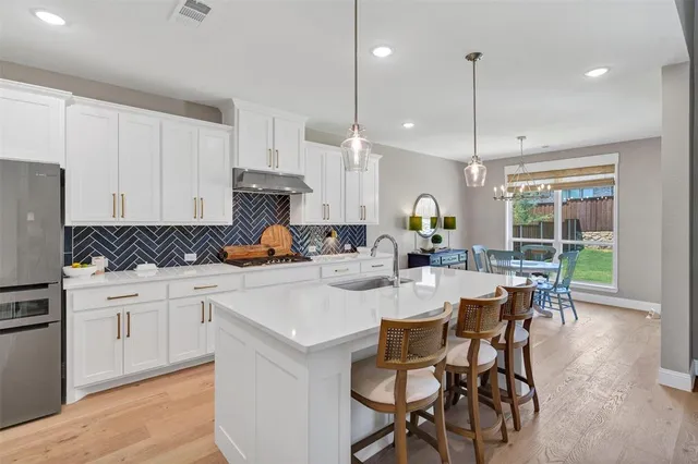 a kitchen with white cabinets and appliances