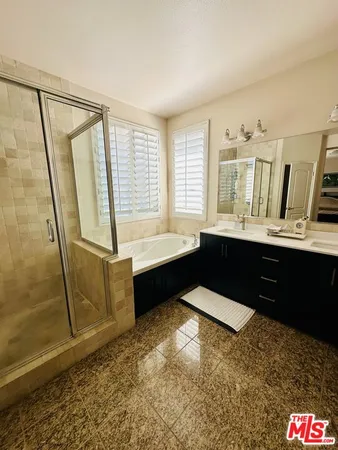 a spacious bathroom with a tub a sink and a mirror