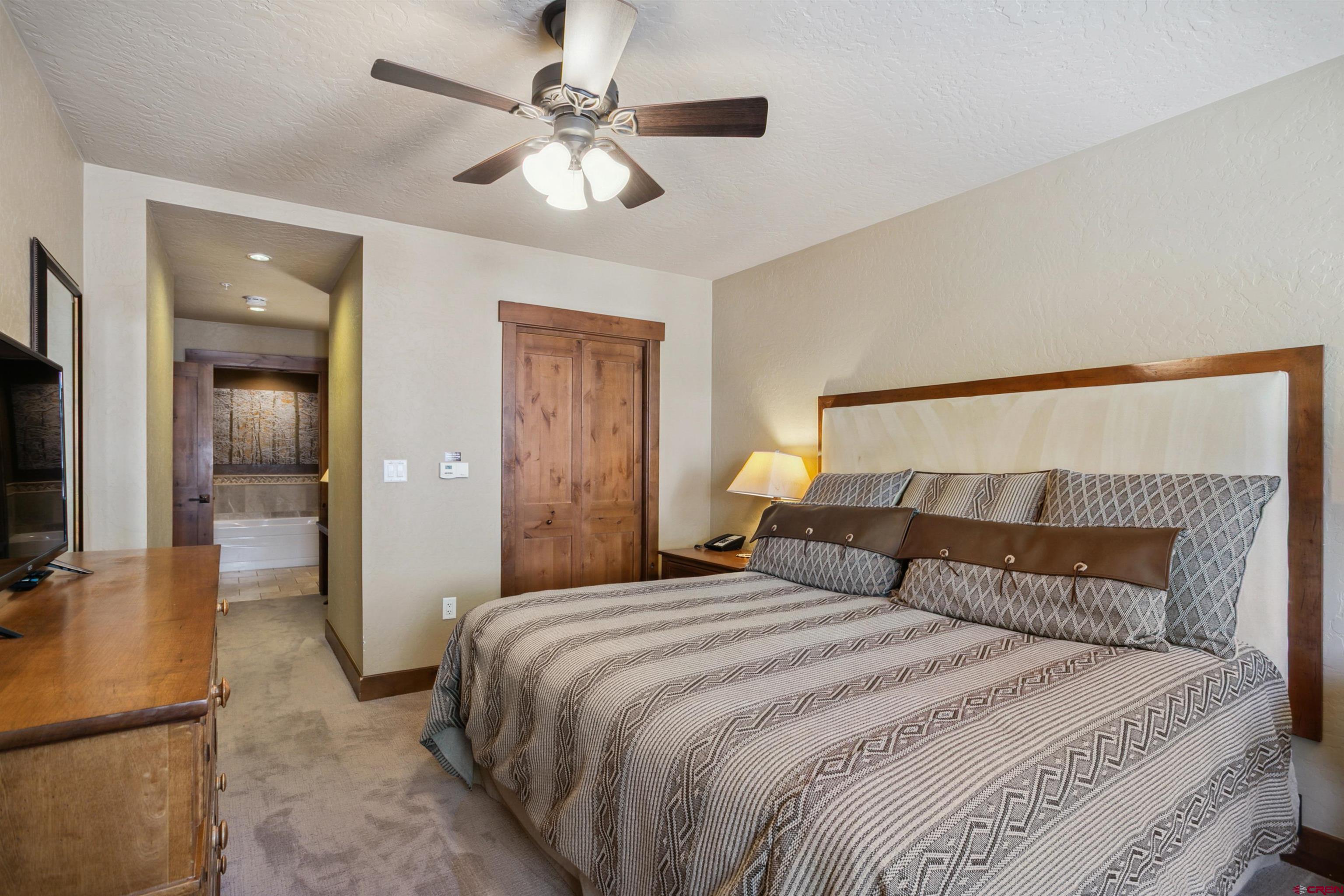 24 Sheol Street, Unit R302 Durango, CO 81301 - Photo 29 of 45 a bedroom with a large bed and a chandelier
