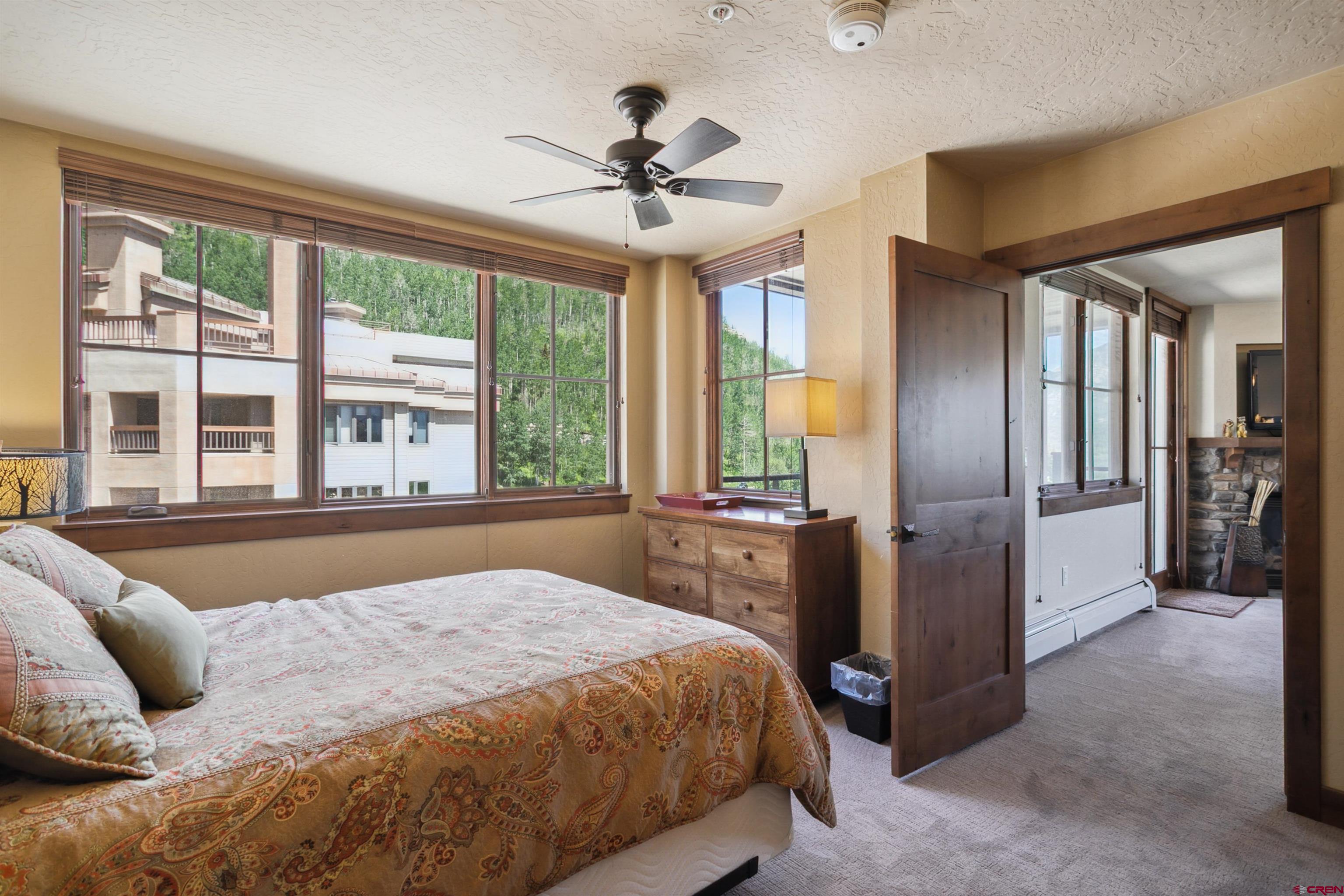 24 Sheol Street, Unit R302 Durango, CO 81301 - Photo 37 of 45 a bedroom with a large bed and a chandelier fan