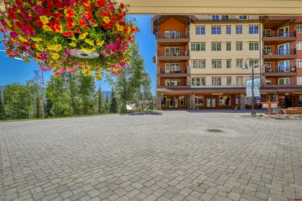 a front view of a building with multi story parking space and trees
