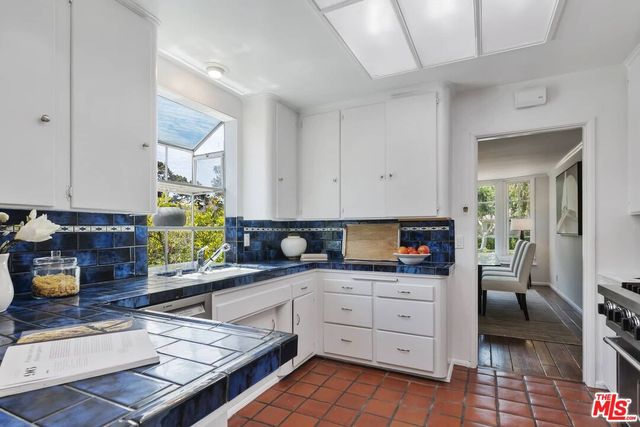 a kitchen with granite countertop a sink a stove and cabinets