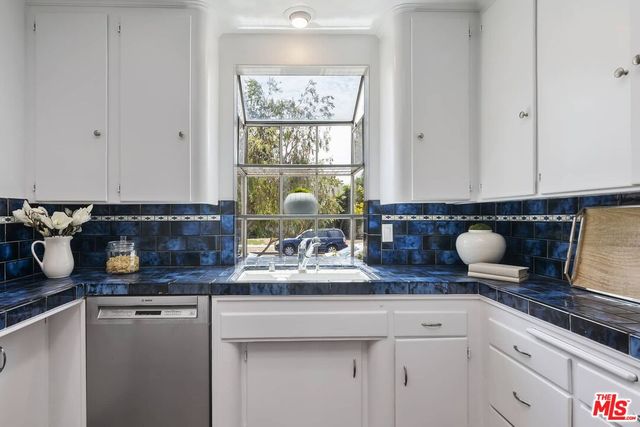 a kitchen with stainless steel appliances granite countertop a sink and a white cabinets