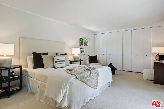 a large bedroom with a bed and dresser