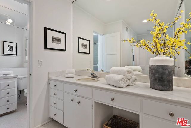 a bathroom with a granite countertop sink mirror and vanity