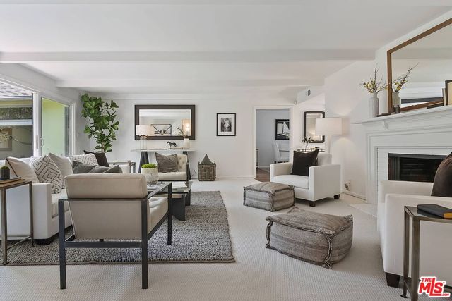a living room with furniture a fireplace and a large window