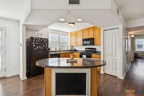 a kitchen with granite countertop a stove and a refrigerator