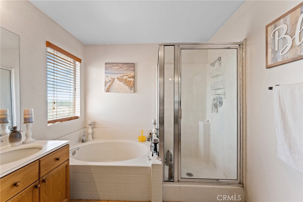 5922 Abernathy Drive Riverside, CA 92507 - Photo 16 of 29 a bathroom with a sink a mirror a window and a shower
