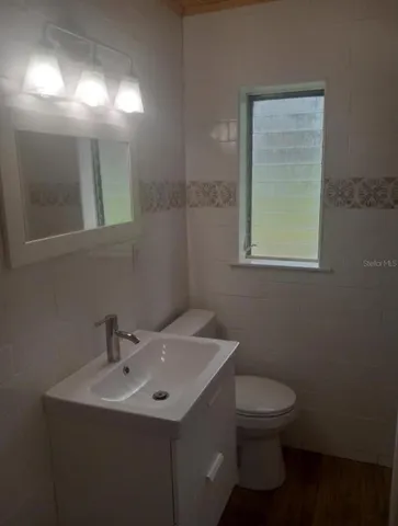 a bathroom with a toilet sink and mirror
