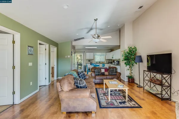a kitchen with a stove a sink dishwasher a dining table and chairs with wooden floor