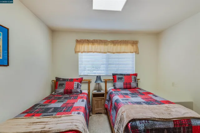 a bedroom with two beds and a window