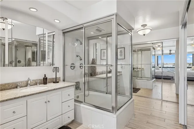 a bathroom with a granite countertop sink mirror and shower