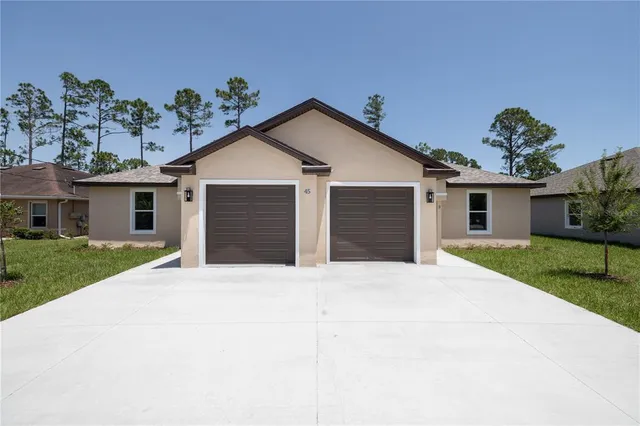 front view of a house with a yard and a trees