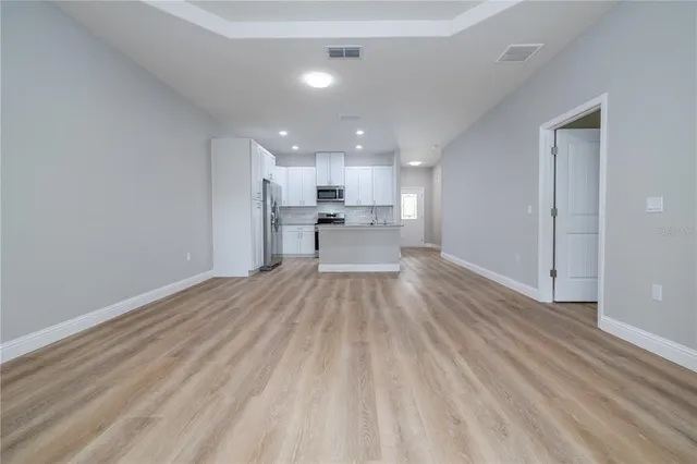 a view of a kitchen with a sink and wooden floor