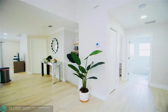 a white vase with white and yellow flowers