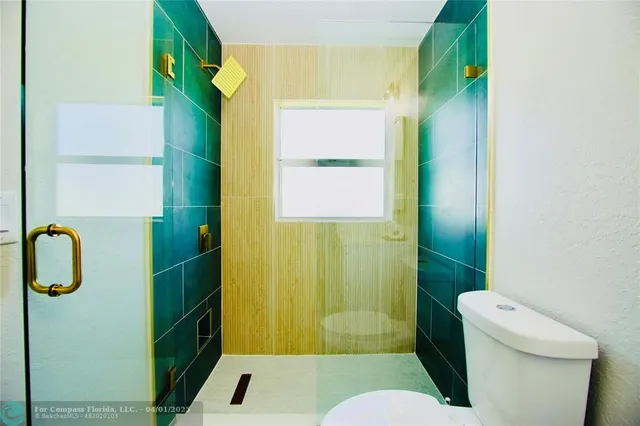 a bathroom with a toilet and a shower