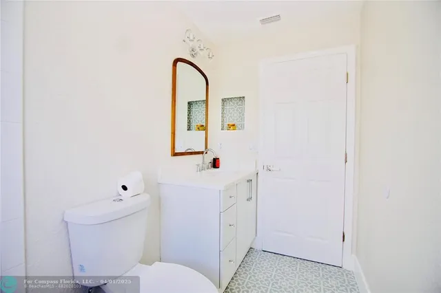 a bathroom with a sink a toilet and a mirror