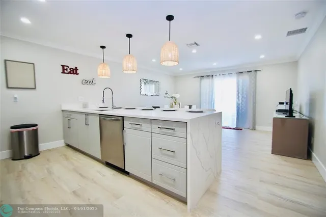 a kitchen with kitchen island a sink stainless steel appliances and cabinets