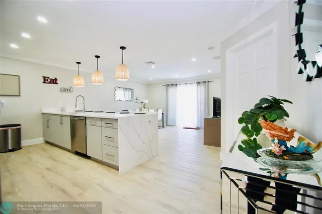 a large white kitchen with wooden floor
