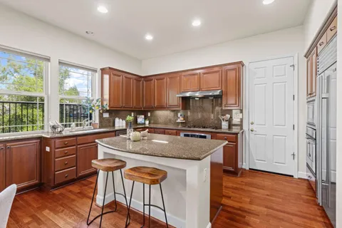 a kitchen with stainless steel appliances granite countertop a refrigerator and a stove top oven