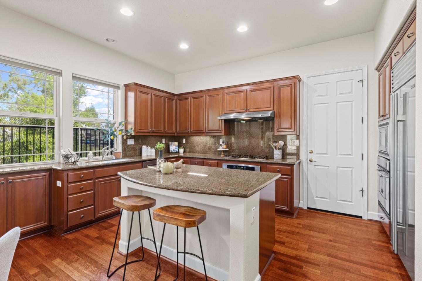 7071 Eagle Ridge Drive Gilroy, CA 95020 - Photo 19 of 72 a kitchen with stainless steel appliances granite countertop wooden cabinets a sink a stove a dining table and chairs