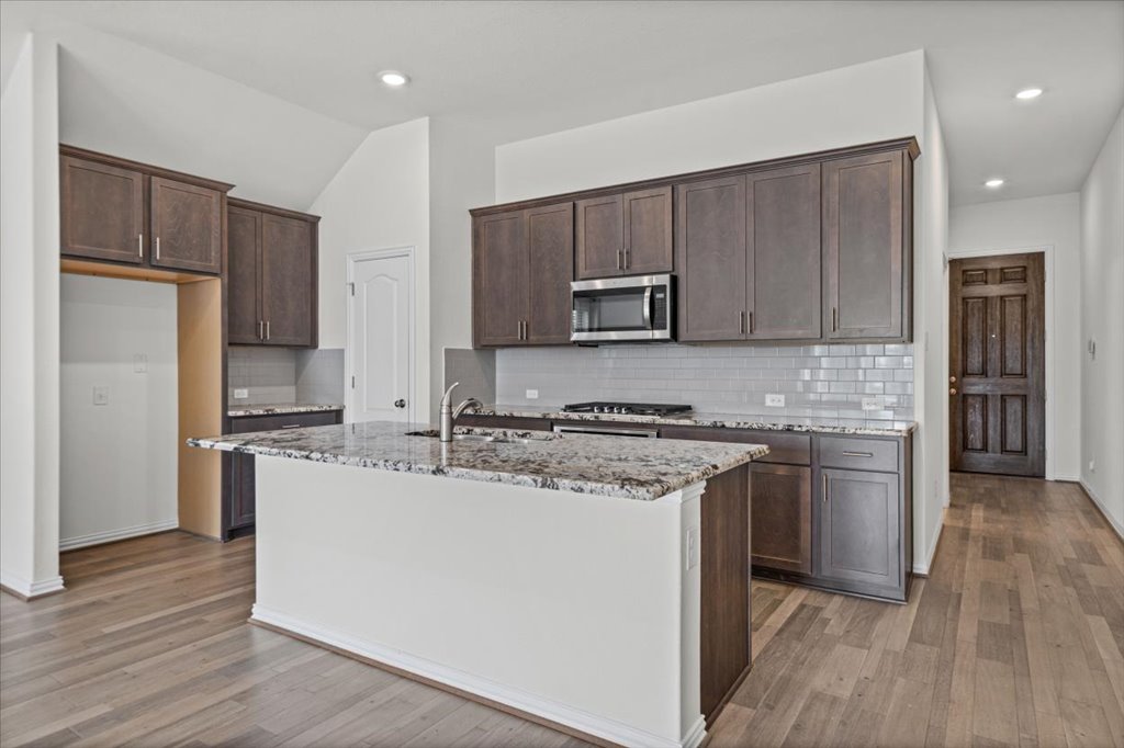 277 Spinnaker Loop Kyle, TX 78640 - Photo 8 of 38 A well-appointed kitchen showcases rich cabinetry and an inviting island with ample counter space.