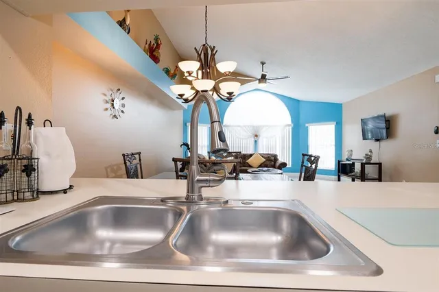 a kitchen with a sink a clock and a chandelier