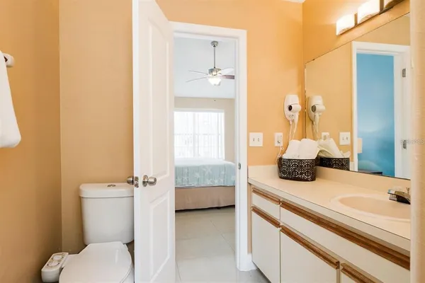 a en suite bathroom with a granite countertop toilet sink and mirror