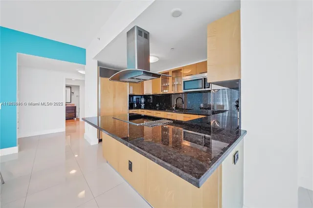 a kitchen with stainless steel appliances granite countertop a sink and a refrigerator