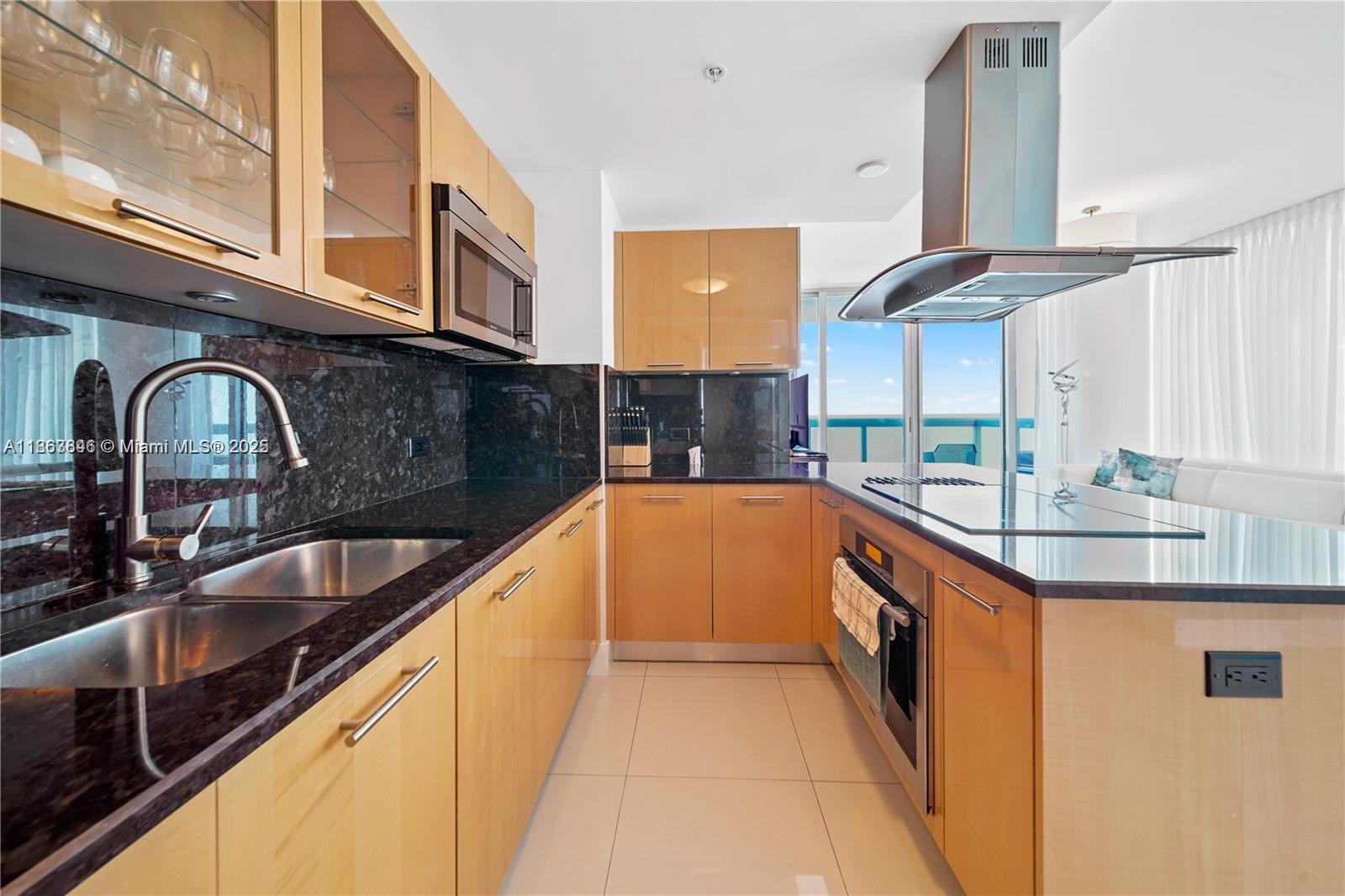 6899 Collins Avenue, Unit 808 Miami Beach, FL 33141 - Photo 18 of 31 a kitchen with stainless steel appliances granite countertop a sink and cabinets