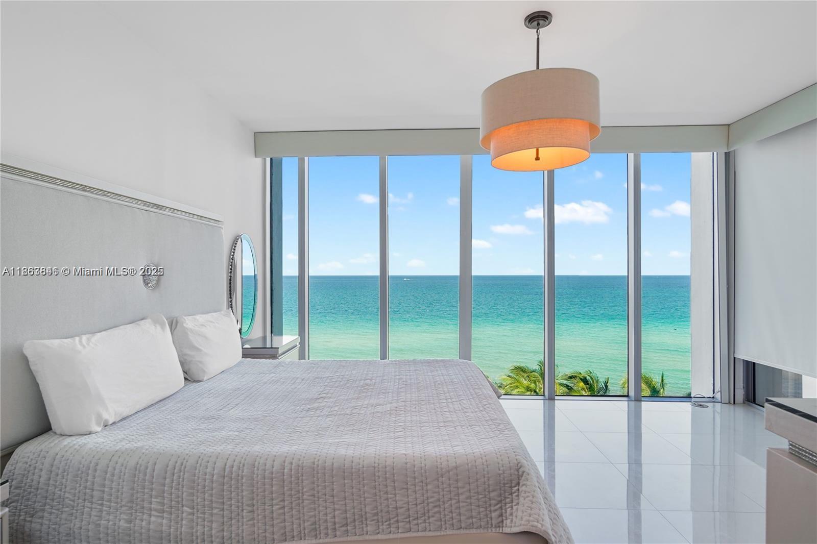 6899 Collins Avenue, Unit 808 Miami Beach, FL 33141 - Photo 20 of 31 a bedroom with a bed and chandelier