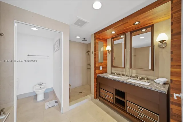 a bathroom with a double vanity sink mirror and toilet