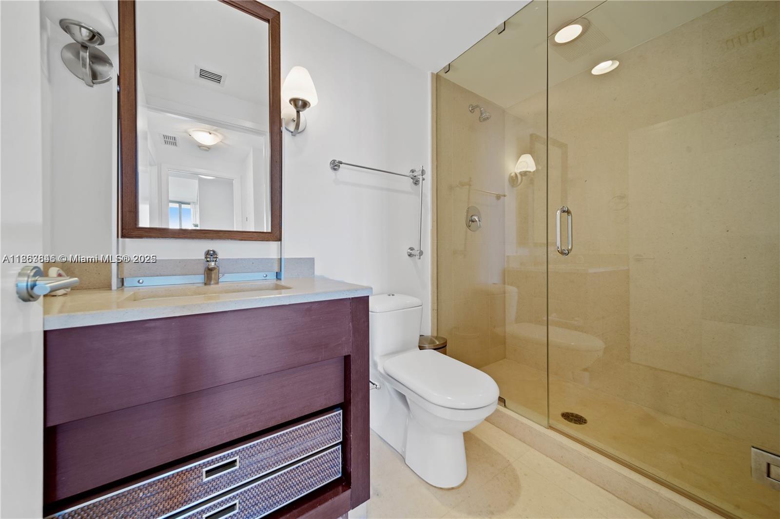 6899 Collins Avenue, Unit 808 Miami Beach, FL 33141 - Photo 30 of 31 a bathroom with a sink a toilet and shower