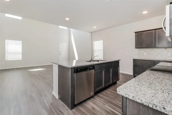 a kitchen with stainless steel appliances granite countertop a wooden cabinets a sink and a wooden floors