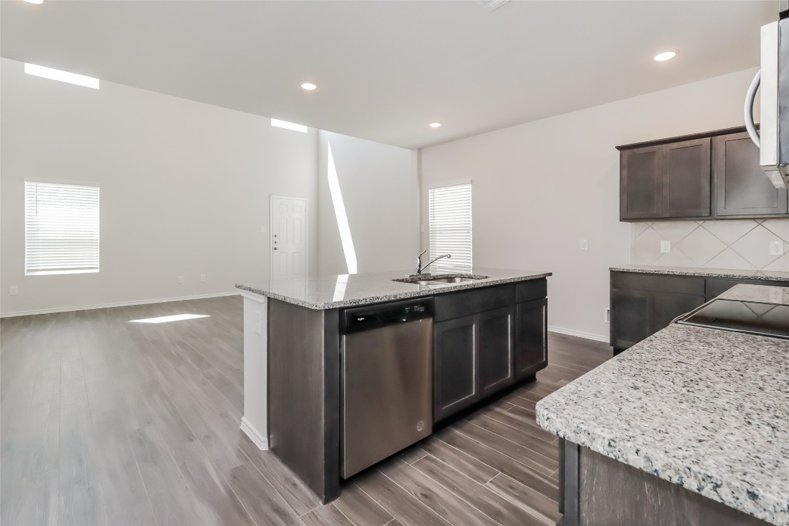 15200 Estrella Road East Houston, TX 77073 - Photo 5 of 13 a kitchen with stainless steel appliances granite countertop a wooden cabinets a sink and a wooden floors