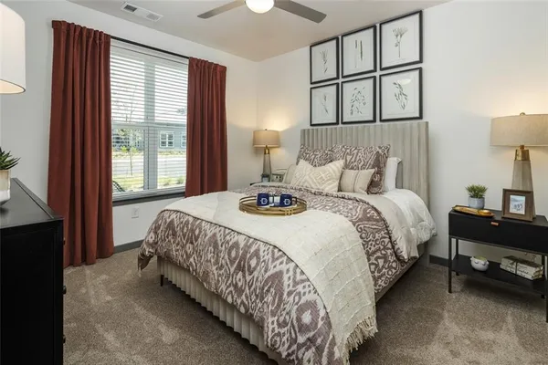 a bedroom with a bed a dresser and next to a window