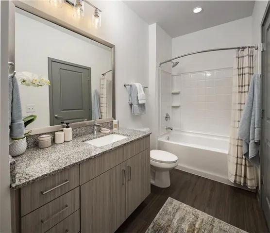 a bathroom with a granite countertop sink toilet and shower