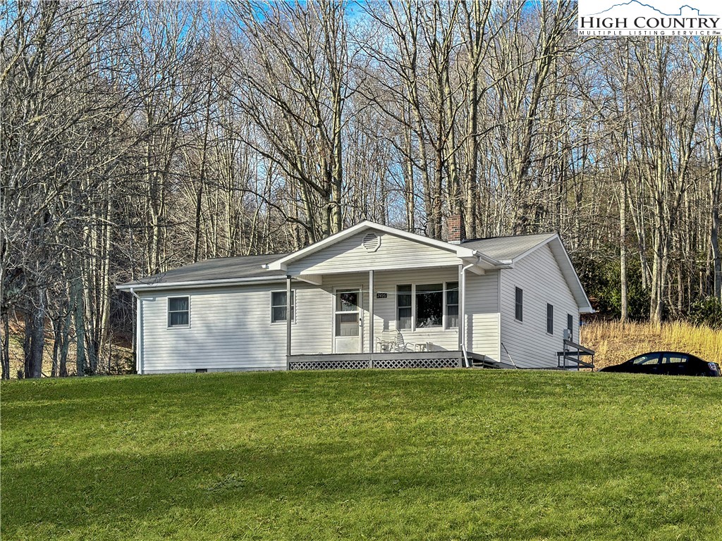 2496 Tucker Road Lansing, NC 28643 - Photo 1 of 20 a front view of a house with a garden