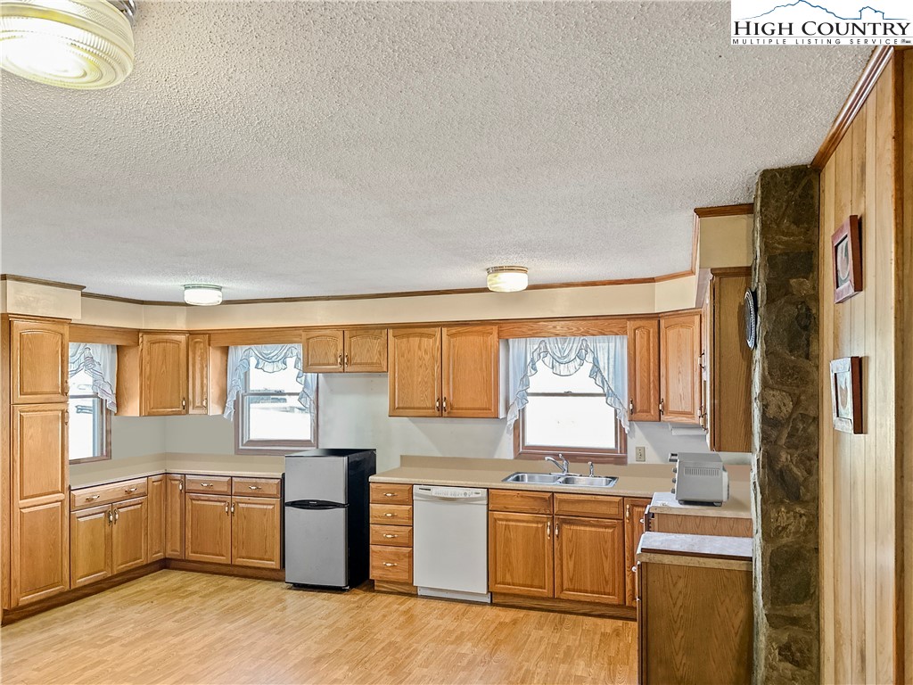 2496 Tucker Road Lansing, NC 28643 - Photo 12 of 20 a kitchen with a window wooden cabinets and stainless steel appliances