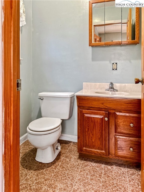 2496 Tucker Road Lansing, NC 28643 - Photo 17 of 20 a bathroom with a toilet a sink and mirror