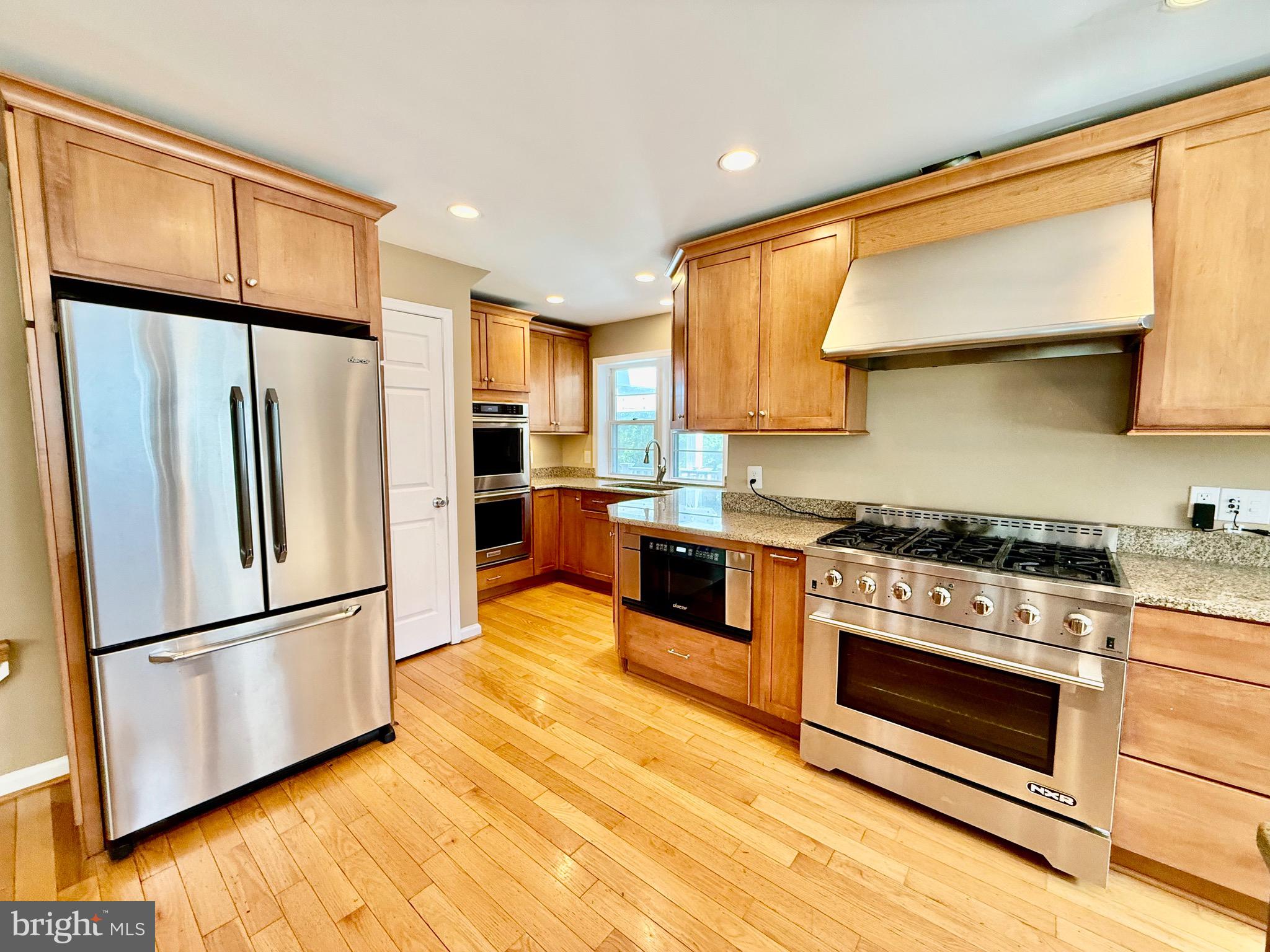 6605 Keene Drive Springfield, VA 22152 - Photo 3 of 127 a kitchen with granite countertop stainless steel appliances a refrigerator a stove top oven and cabinets