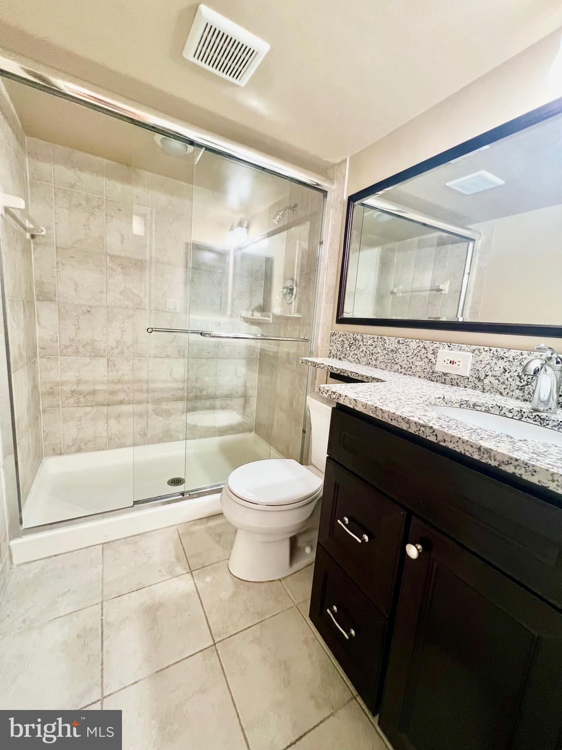 6605 Keene Drive Springfield, VA 22152 - Photo 81 of 127 a bathroom with a granite countertop sink toilet a mirror and shower