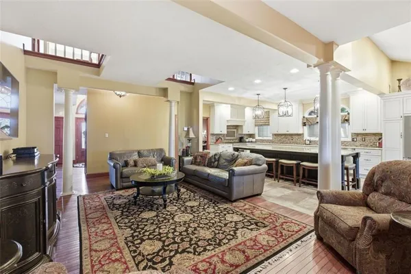 a living room with furniture wooden floor and a view of kitchen