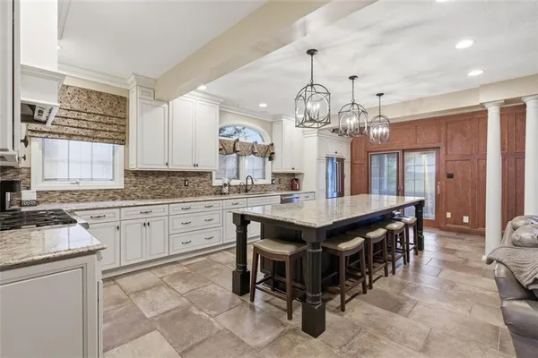 a kitchen with center island table and chairs in it