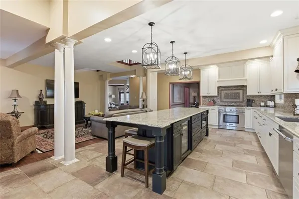 a large kitchen with kitchen island a large island in the center and stainless steel appliances