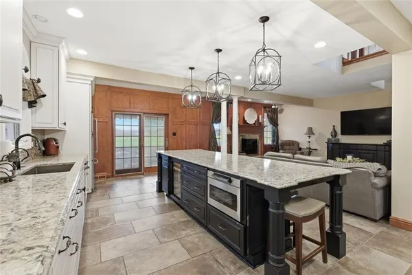 a kitchen with stainless steel appliances granite countertop a stove oven and a view of living room