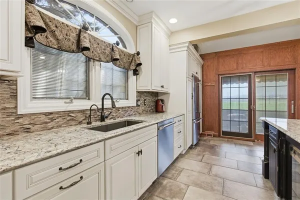 a spacious bathroom with a granite countertop sink and a mirror