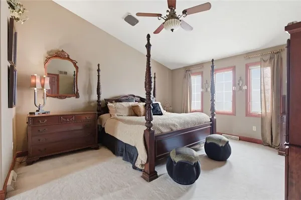 a bedroom with a large bed and a chandelier