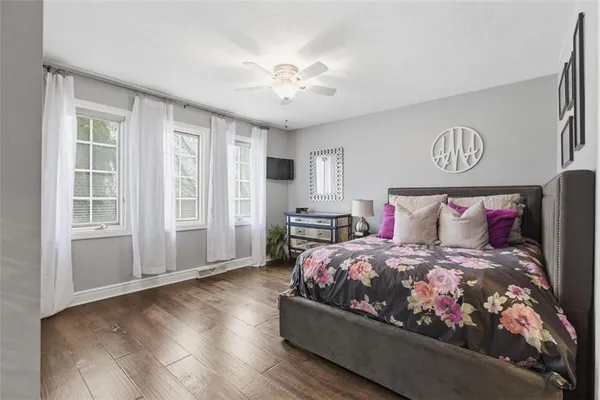 a bedroom with a bed and a flat tv screen on a dresser