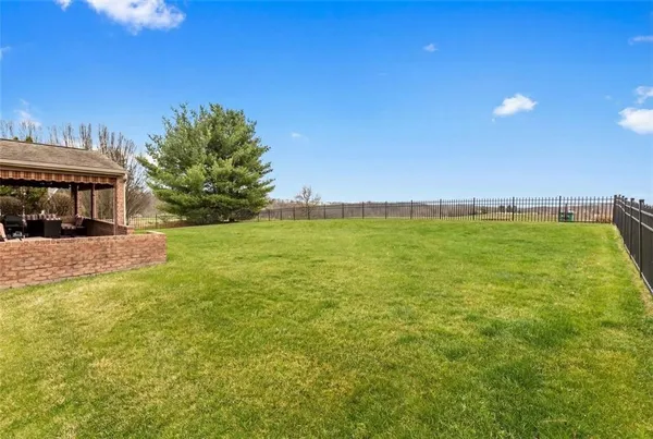 a view of a big house with a big yard and large trees